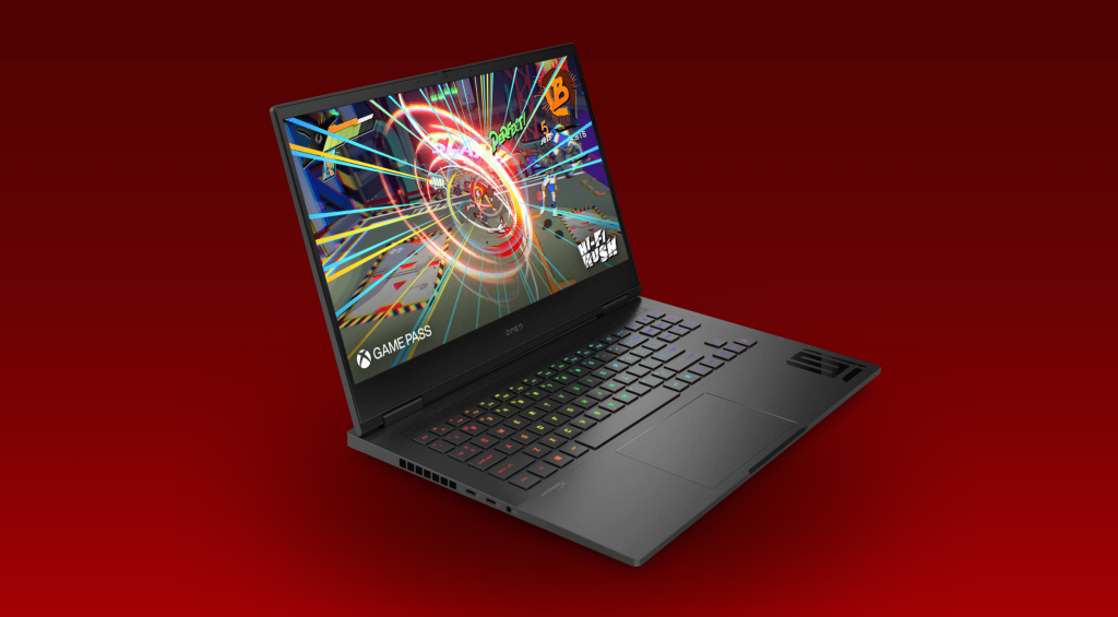 HP OMEN 16 laptop open on a desk, showcasing its sleek design and backlit keyboard.